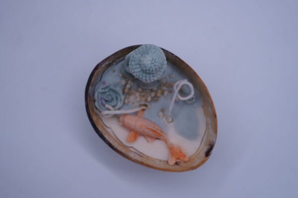 A small statue or representation of Buddha often associated with koi fish likely designed aesthetic candle (2) A Small Statue or Representation of Buddha Often Associated with Koi Fish Likely Designed Aesthetic Candle